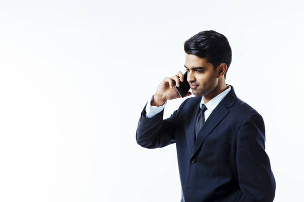 Portrait of a handsome businessman entrepreneur talking on the  phone, smiling. looking left. white isolated background. - Fotografie, Obrázek