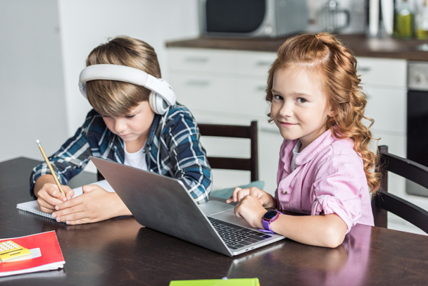 entzückende kleine Bruder und Schwester Hausaufgaben machen und Laptop benutzen - Foto, Bild