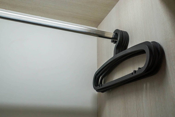 selective focus black modern coat hanger in wardrobe in hotel bedroom - Fotoğraf, Görsel