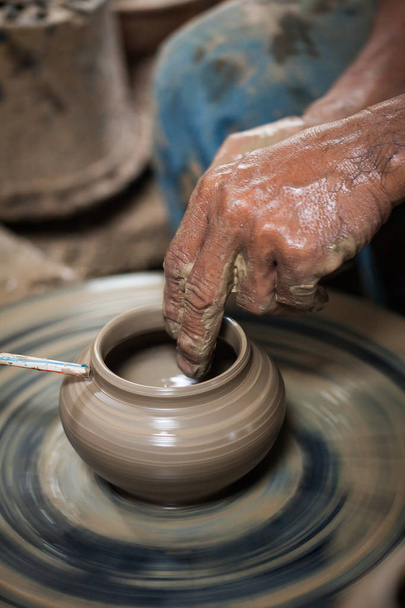 dirty hands making pottery in clay on wheel - Zdjęcie, obraz