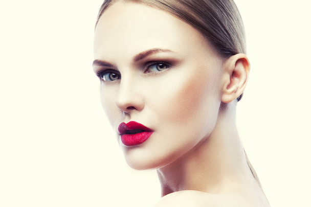 Portret van een jonge vrouw met natuurlijke make-up en rode lippen op witte achtergrond - Foto, afbeelding