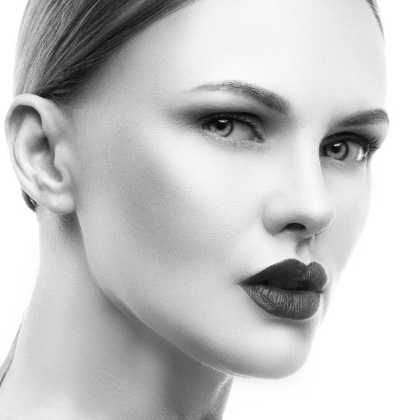 retrato de mujer joven con maquillaje natural y labios oscuros sobre fondo blanco
 - Foto, Imagen