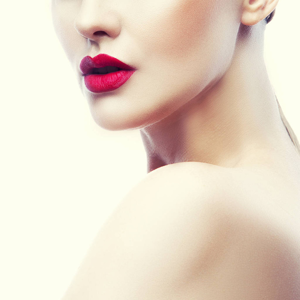 自然化粧品および白い背景の赤い唇の若い女性の肖像画をトリミング - 写真・画像