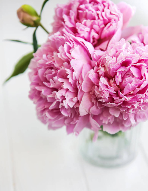 Vase with pink peony flowers on a white wooden table - Foto, immagini