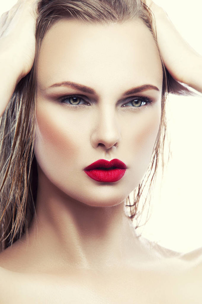portrait of young woman with natural makeup and red lips on white background - Fotó, kép