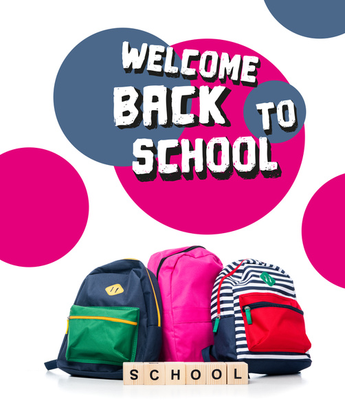three colored schoolbags and wooden cubes with word school isolated on white, with "welcome back to school" lettering - Photo, Image