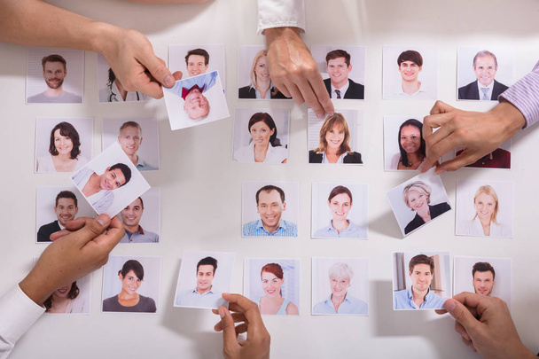 Elevated View Of Businesspeople Selecting Candidate Photo On White Background - Photo, Image