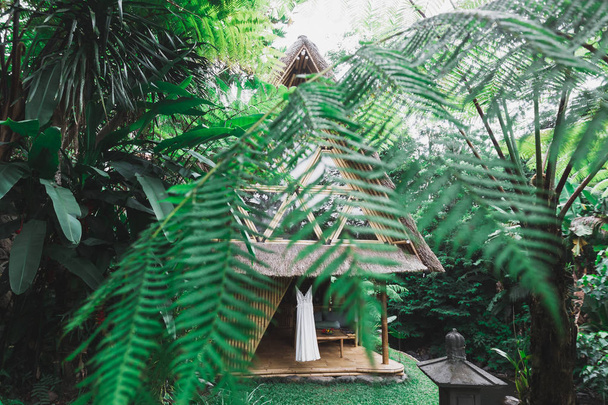 Abito da sposa bianco appeso sulla terrazza della casa rustica in legno in giardino
  - Foto, immagini