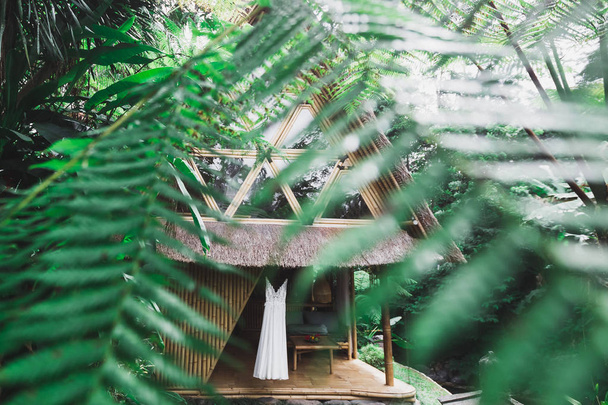 Biała suknia wisi na taras drewniany rustykalny dom w ogrodzie  - Zdjęcie, obraz