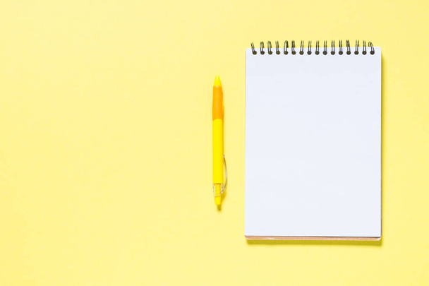 Cuaderno, pluma y smartphone en amarillo
 - Foto, Imagen