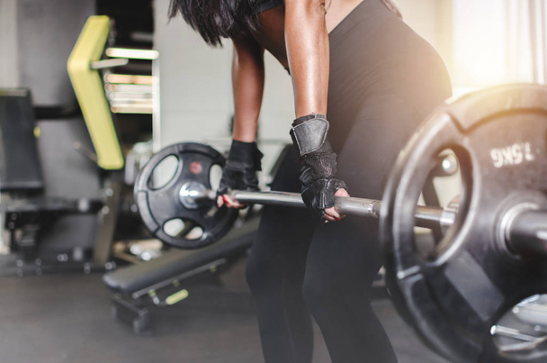 Cropped image of attractive woman doing deadlift in a gym. - Foto, afbeelding