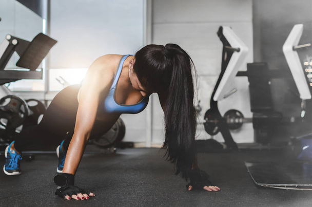 Young attractive woman doing push-ups at gym. - Foto, immagini