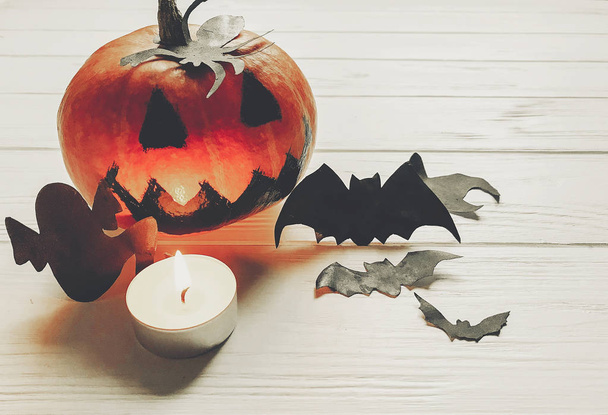 Хэллоуин. жуткий Джек фонарь тыква с призраками летучих мышей и паук черные украшения в свете на белом деревянном фоне. Праздник. сезонные поздравления. Счастливый Хэллоуин
 - Фото, изображение