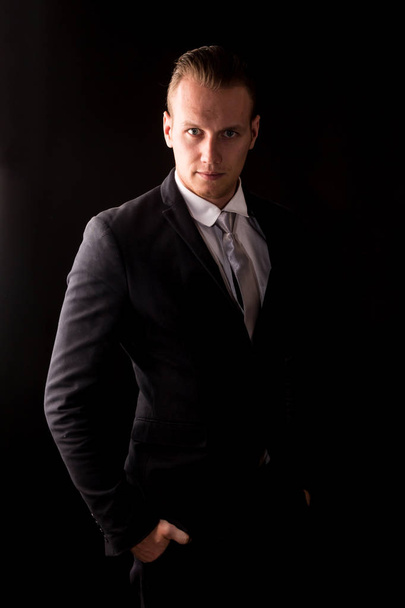 Handsome Businessman with black suit isolated on black background - Photo, image