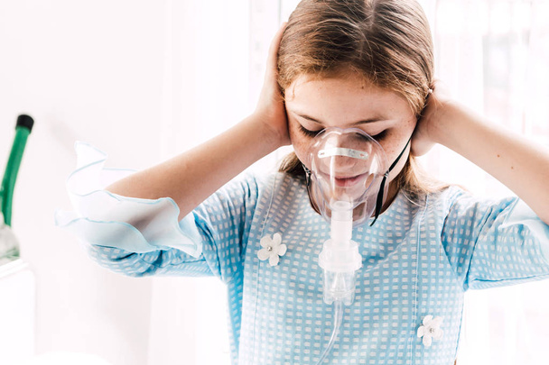 Nettes kleines Mädchen mit Vernebelungsmaske im Krankenhaus - Foto, Bild