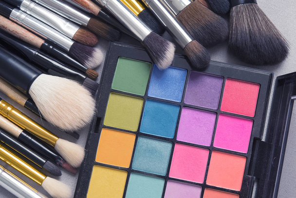 schöne Make-up Hintergrund. Make-up Pinsel auf bunte Make-up-Palette mit Copyspace. - Foto, Bild