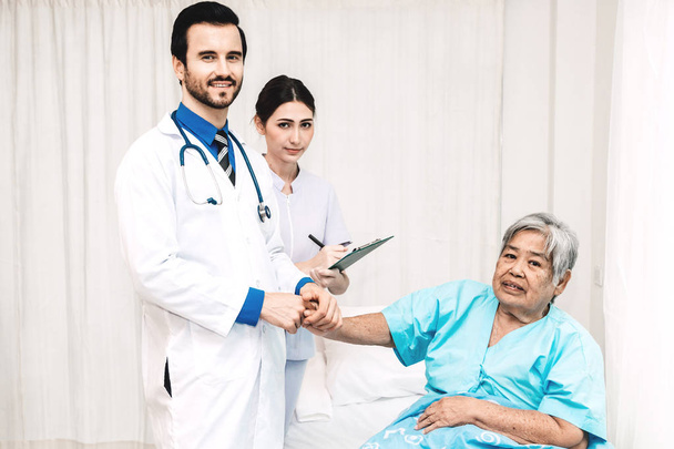Лікар тримає руку пацієнта літнього віку з доглядом та консультуванням у лікарні. Охорона здоров'я та медицина
 - Фото, зображення