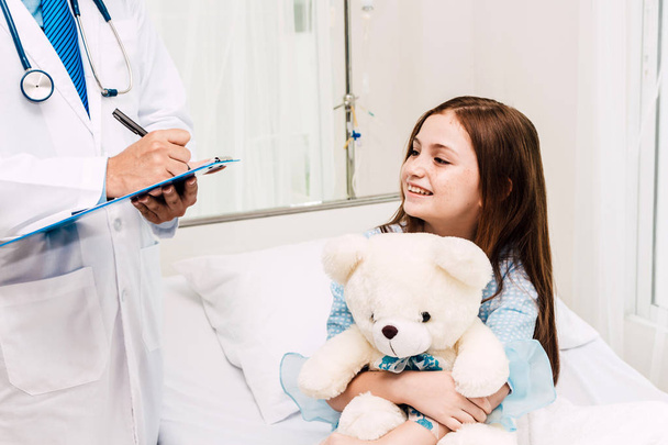 Ο γιατρός διαβούλευση και ελέγξτε τις πληροφορίες με το κοριτσάκι στο νοσοκομείο. Ένα μικρό κορίτσι έχει sick.healthcare και ιατρική - Φωτογραφία, εικόνα