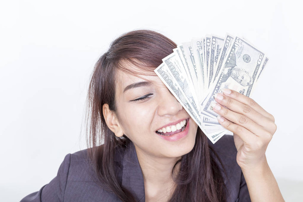 Üzletasszony ruha az irodájába, és tartja a pénz a kezében közelében mosolygó arc. - Fotó, kép