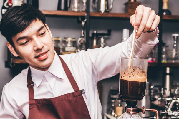 Handsome barista making coffee on syphon coffee maker in the cafe - Photo, Image