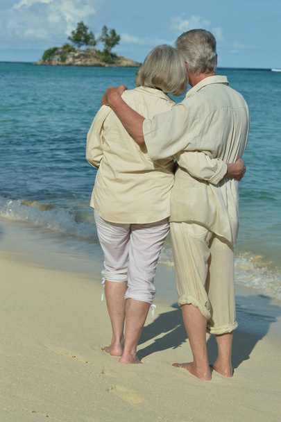  bejaarde echtpaar rusten op het strand. Reizen - Foto, afbeelding