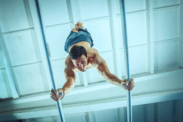 The sportsman during difficult exercise, sports gymnastics - Photo, Image