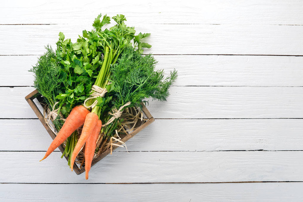 Fresh carrots, parsley and dill. Organic food. On a white wooden background. Top view. Free space for text. - Photo, Image