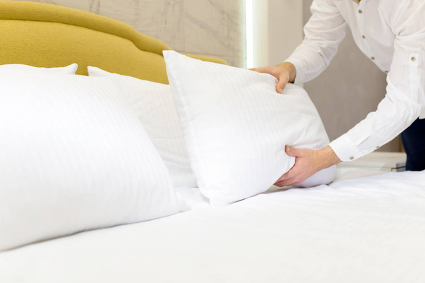 hotel staff setting up pillow on bed - Foto, Imagem