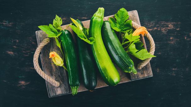 Fresh green zucchini on a black wooden table. Top view. Copy space. - Foto, Bild