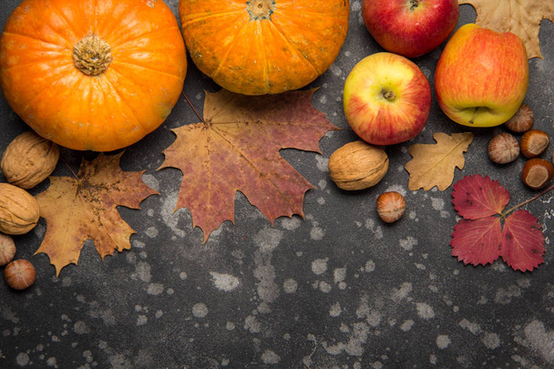 リンゴ、かぼちゃ、ヘーゼル ナッツ、クルミ、暗い背景に落ちた葉。トップ ビューのテキストのためのスペースにコピーします。感謝祭の背景 - 写真・画像