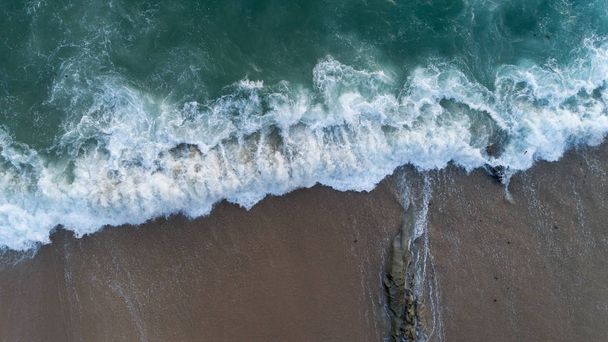Drohnenaufnahmen von einer malerischen Meereslandschaft vor dem Strand von Phuket in Thailand mit einer Welle, die auf die Felsen kracht - Foto, Bild