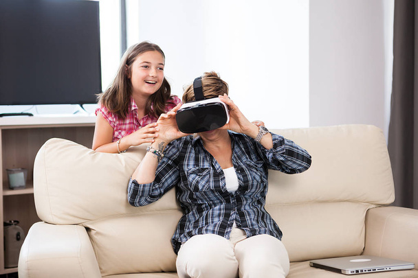 Жінка середнього віку в гарнітурі віртуальної реальності і насолоджується нею
 - Фото, зображення