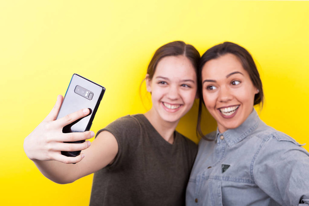 Joyeux rire et sourire sœurs prendre un selfie
 - Photo, image