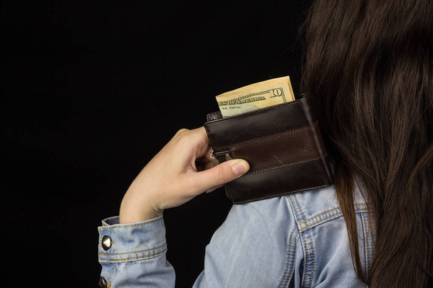 woman holding a wallet with money, close-up, Black background, banknote, dollars - Foto, Bild