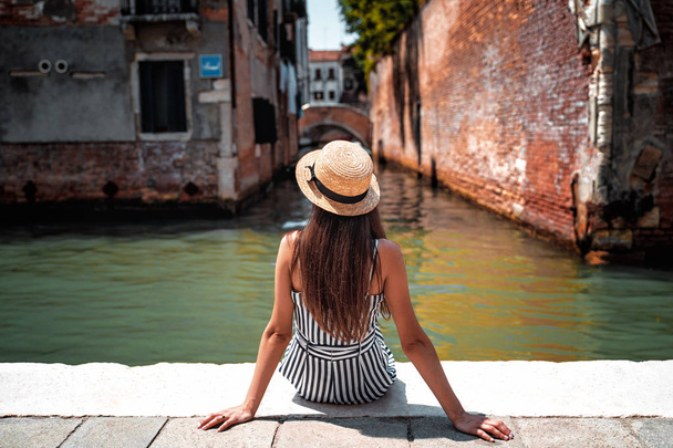 Girl has a rest near the canal in Venice - Фото, изображение