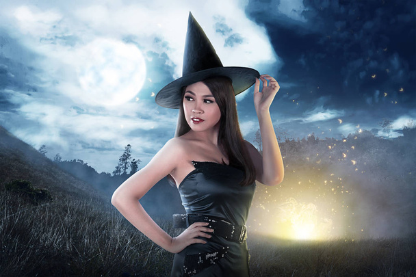 Beautiful asian witch woman with hat posing with full moon background - Fotografie, Obrázek