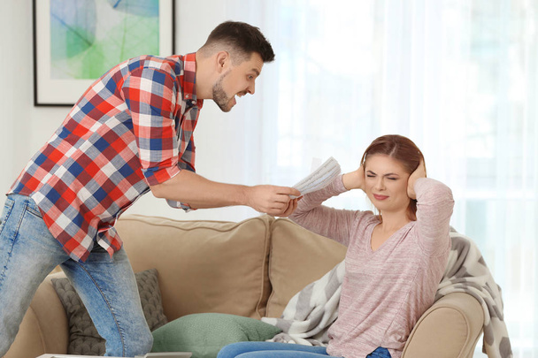 Angry man scolding his wife for overspending at home - Photo, image