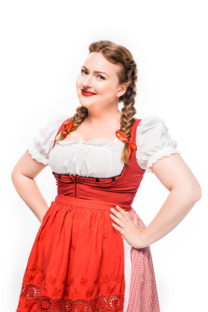 attractive oktoberfest waitress in traditional bavarian dress standing akimbo isolated on white background - Photo, Image