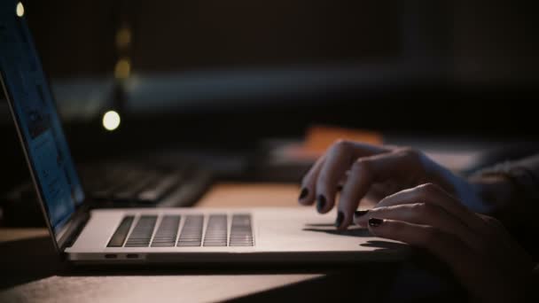 ノート パソコンのタッチパッドに女性の指をクローズ アップ。少女は、暗闇の中でネット サーフィンします。オンライン ショッピング。自宅で仕事。4 k. - 映像、動画