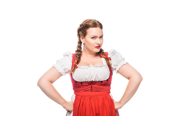 fiduciosa cameriera oktoberfest in abito tradizionale bavarese in piedi con le mani sulla vita isolata su sfondo bianco
 - Foto, immagini