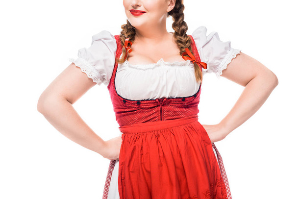 geschnittenes Bild einer Oktoberfestkellnerin in traditioneller deutscher Tracht mit den Händen an der Taille isoliert auf weißem Hintergrund - Foto, Bild