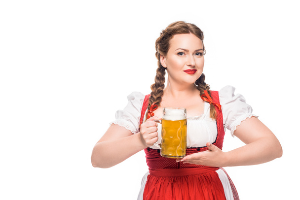 attractive oktoberfest waitress in traditional bavarian dress holding mug of light beer isolated on white background - Zdjęcie, obraz