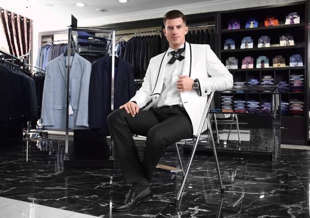 Handsome young man wearing elegant suit in shop - Fotó, kép