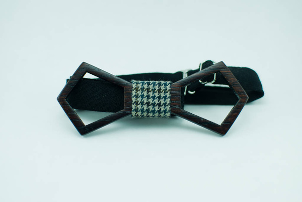 Stylish black wooden bow tie with green-white soft cloth ribbon. Isolated - Photo, Image