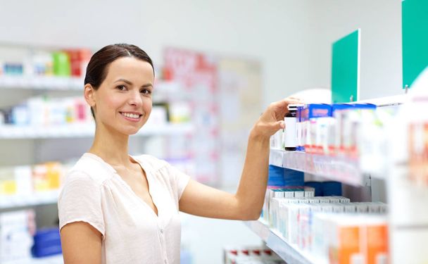 female customer choosing drugs at pharmacy - Фото, изображение