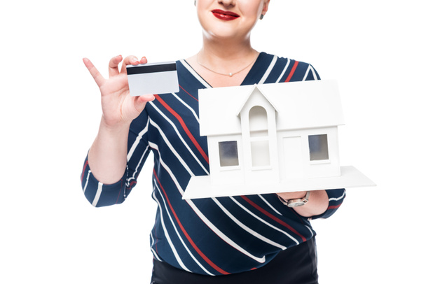 cropped image of female realtor showing maquette of new house and credit card isolated on white background  - Zdjęcie, obraz