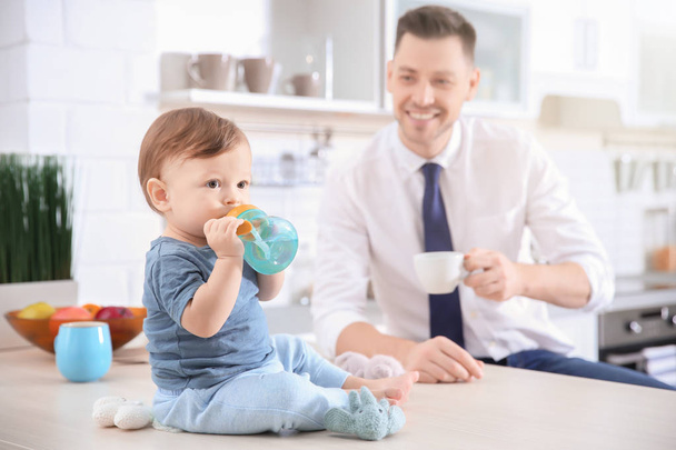Morning of cute baby boy and his dad in kitchen - 写真・画像