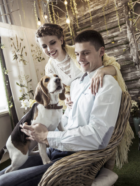 portrait of happy couple with pet in the living room - Фото, изображение