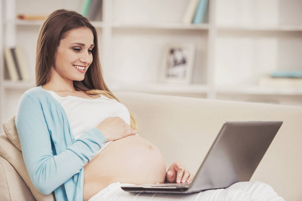 Pregnant Girl with Bare Stomach Using Laptop. - Photo, Image