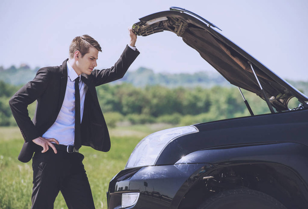 Worried Young Businessman Examining Broken Car. - Foto, Imagen